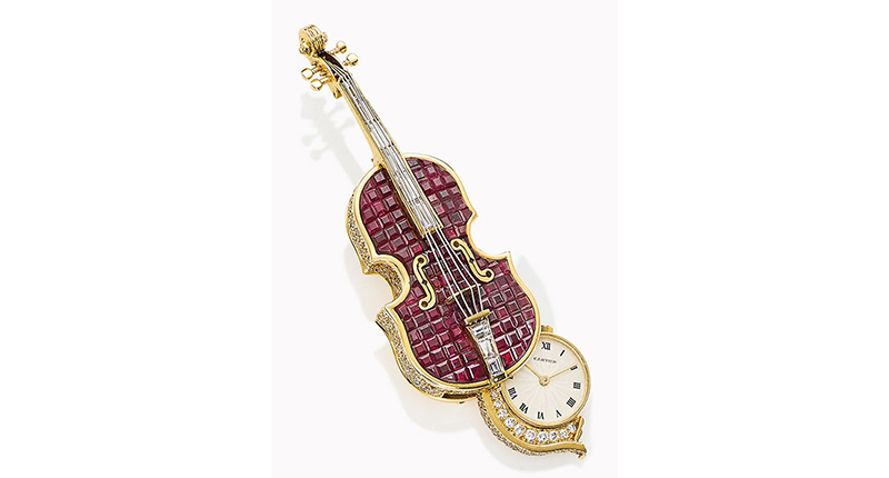 This ruby and diamond novelty brooch by Cartier is modeled after a violin, with one side opening to reveal a watch with a circular dial, Roman numerals and quartz movement, all mounted in gold. It could sell for up to $15,000.