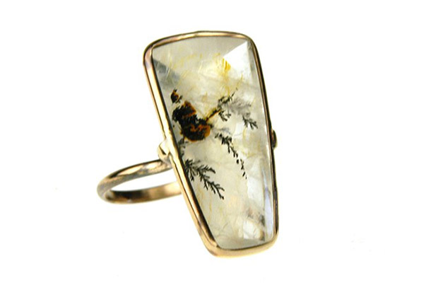 Russell Jones’ “Dendritic Pinch” ring features a shield-shaped buff top dendritic quartz set in 14-karat gold ($1,350).<br />
<a href="http://www.russelljonesjewelry.com/" target="_blank"><span style="color: rgb(255, 0, 0);">russelljonesjewelry.com</span></a> Russell Jones’ “Dendritic Pinch” ring features a shield-shaped buff top dendritic quartz set in 14-karat gold ($1,350).<br />
<a href="http://www.russelljonesjewelry.com/" target="_blank"><span style="color: rgb(255, 0, 0);">russelljonesjewelry.com</span></a>