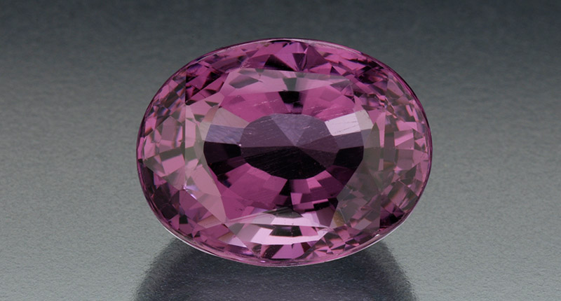 A 13.23-carat oval mixed-cut purple taaffeite from Sri Lanka (Image courtesy of the Dr. E. Gubelin Collection. Photo credit: Robert Weldon/GIA)