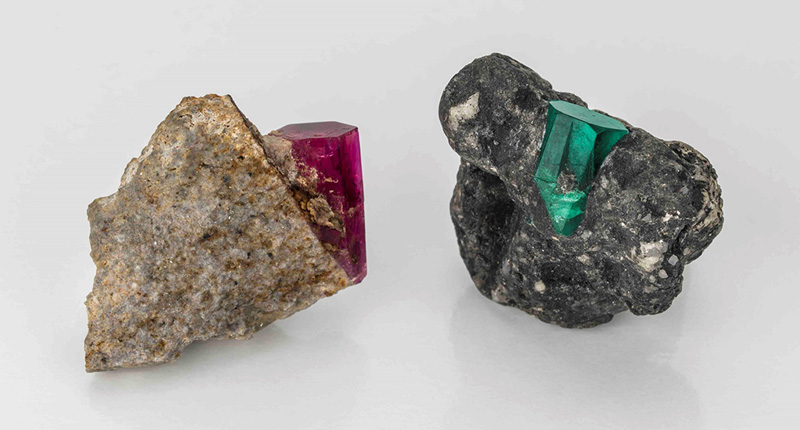 This photo from Equatorian Imports shows a red beryl mineral specimen alongside an emerald crystal to showcase the similarities between the two varieties of beryl.