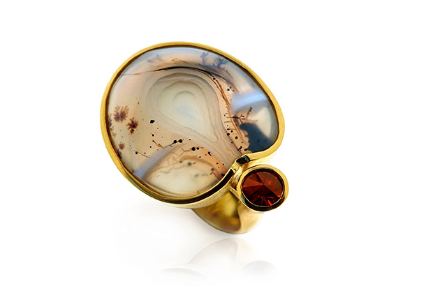 This specialty-cut agate ring by Tom Munsteiner is paired with a Spirit Sun-cut spessartine garnet, set in 18-karat gold (price upon request). <br />
<a href="http://www.munsteiner-cut.de/" target="_blank"><span style="color: rgb(255, 0, 0);">munsteiner-cut.de</span></a> This specialty-cut agate ring by Tom Munsteiner is paired with a Spirit Sun-cut spessartine garnet, set in 18-karat gold (price upon request). <br />
<a href="http://www.munsteiner-cut.de/" target="_blank"><span style="color: rgb(255, 0, 0);">munsteiner-cut.de</span></a>
