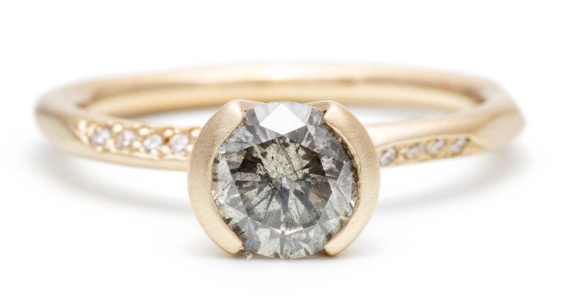 The gray diamond "Ravine Ring" with open-style bezel in 14-karat yellow gold with white diamond pave from Rebecca Overmann, co-founder of the Melee show