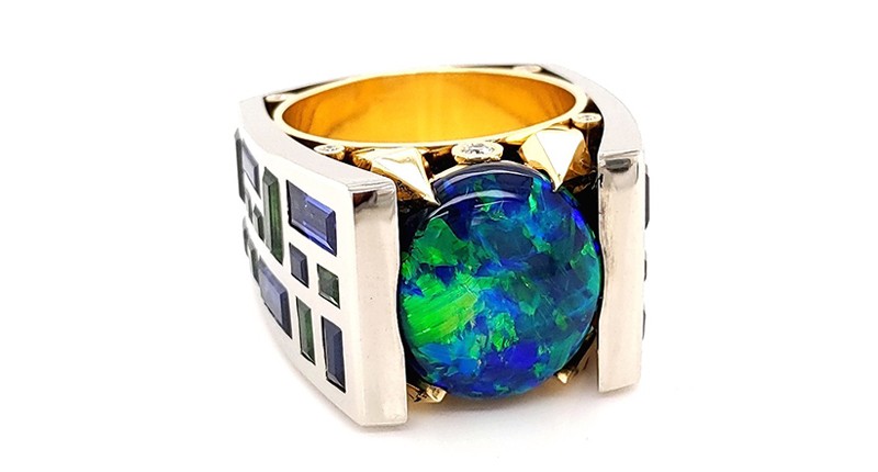 <strong>Best Use of Platinum and Color.</strong> Adam Neeley of Somewhere In The Rainbow’s platinum and 18-karat yellow gold “Dark Knight” ring featuring a 9.81-carat black opal accented with blue sapphires (5.06 total carats), tsavorite garnets (2.56 total carats), and diamonds (0.28 total carats) <strong>Best Use of Platinum and Color.</strong> Adam Neeley of Somewhere In The Rainbow’s platinum and 18-karat yellow gold “Dark Knight” ring featuring a 9.81-carat black opal accented with blue sapphires (5.06 total carats), tsavorite garnets (2.56 total carats), and diamonds (0.28 total carats)