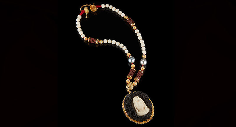 The “Bodhisattva of Compassion” pendant features tagua seeds, Sumatran pearls, black and red wood from Bali and 22-karat gold. The beads are strung in red, per traditional Tibetan Buddhist stringing.