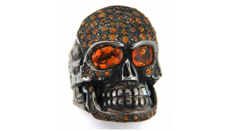 <a href="https://loreerodkin.com/" target="_blank">Loree Rodkin </a> 18-karat white gold pave skull head ring with black rhodium finish, accentedwith yellow gold, orange sapphires, and a white diamond tooth ($20,000)