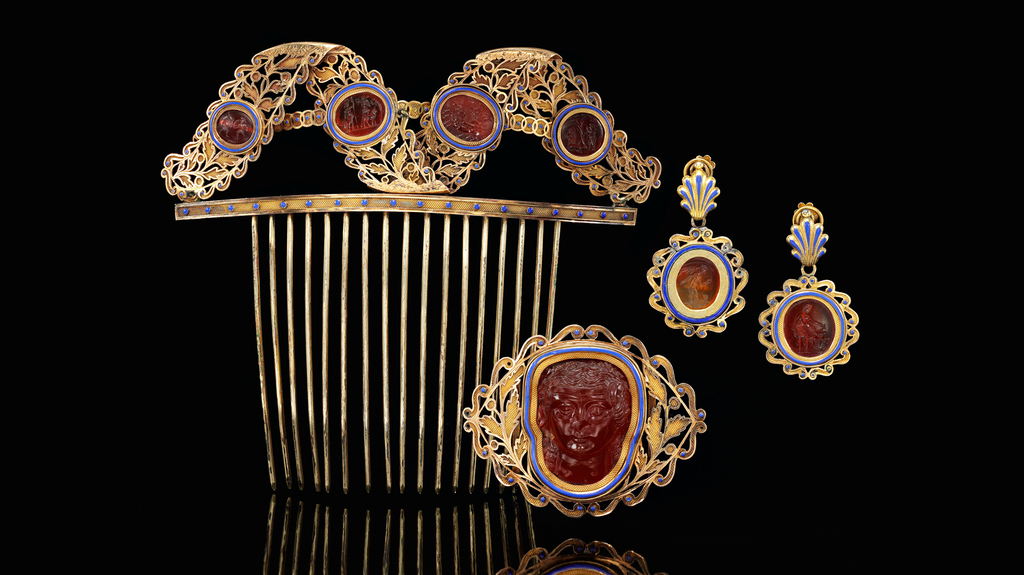 A hair comb, pendant earrings, and belt ornament accompany the matching gold, enamel and carnelian tiara pictured at top of article in the Sotheby’s London sale.