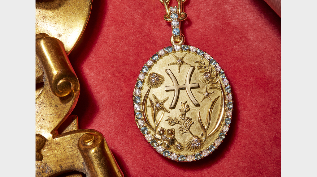 A close-up of a Pisces locket with a diamond and colored gemstone halo