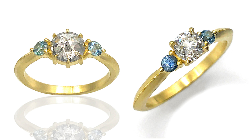 These two rings are “Kingsley” styles. The ring at left features a 0.94-carat gray rose-cut diamond accented with Montana sapphires in 18-karat gold ($5,500), and the ring at right has a 0.31-carat old European cut diamond at center with Montana sapphires accents and 18-karat gold ($6,200). These two rings are “Kingsley” styles. The ring at left features a 0.94-carat gray rose-cut diamond accented with Montana sapphires in 18-karat gold ($5,500), and the ring at right has a 0.31-carat old European cut diamond at center with Montana sapphires accents and 18-karat gold ($6,200).