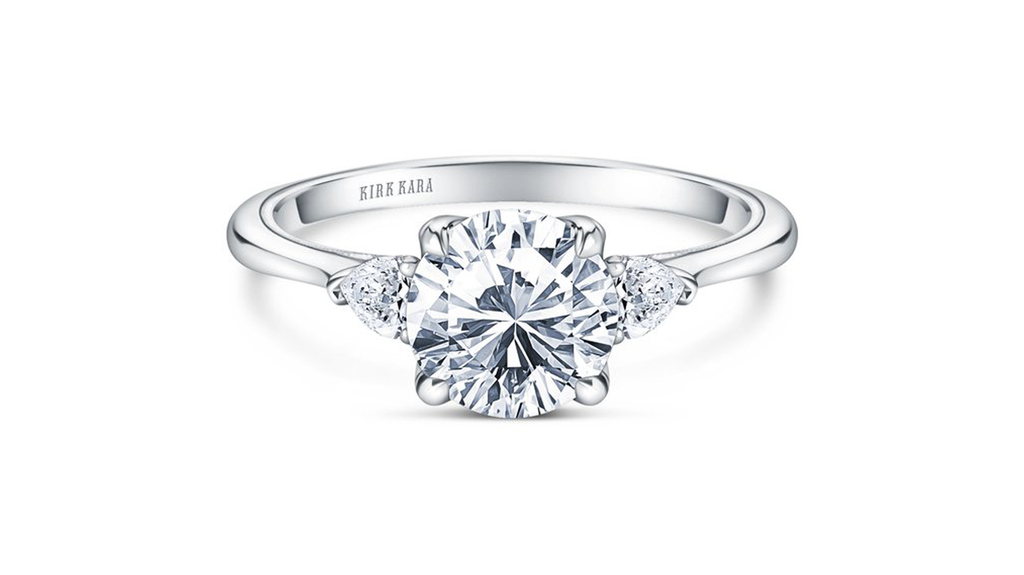 The classic three-stone ring gets an update with fancy-shape side stones. This ring from the “Stella” collection is a new style from Kirk Kara, featuring 0.2 carats of diamonds and milgrain and filigree details ($2,520 without center stone). The classic three-stone ring gets an update with fancy-shape side stones. This ring from the “Stella” collection is a new style from Kirk Kara, featuring 0.2 carats of diamonds and milgrain and filigree details ($2,520 without center stone).