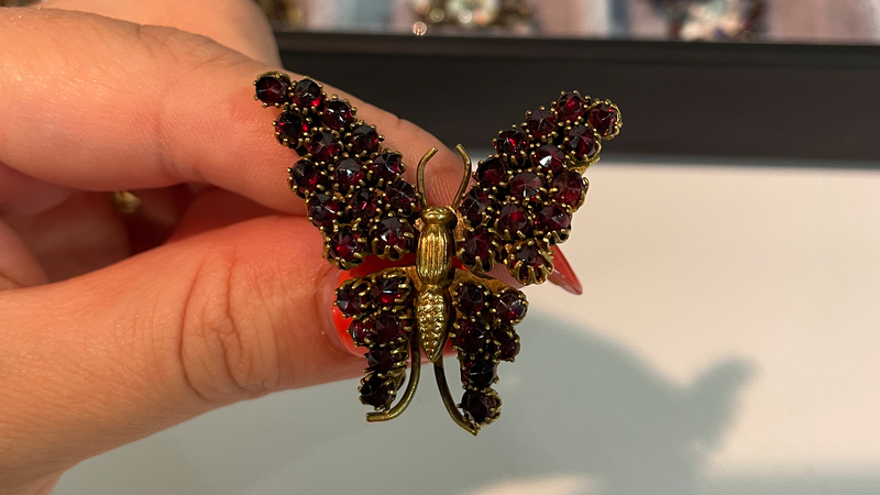 A Victorian revival butterfly brooch in gilt set with garnets