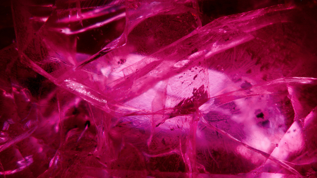Putting the lab-grown ruby under magnification revealed high relief trapped gas bubbles and blue and orange flash effects. (Photomicrograph by Diego Sanchez, field of view 7.19 mm; © GIA) Putting the lab-grown ruby under magnification revealed high relief trapped gas bubbles and blue and orange flash effects. (Photomicrograph by Diego Sanchez, field of view 7.19 mm; © GIA)