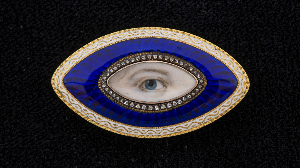 A gold oval Lover’s Eye brooch with a band of diamonds within a blue glass guilloche border surrounded by white enamel, 1890 A gold oval Lover’s Eye brooch with a band of diamonds within a blue glass guilloche border surrounded by white enamel, 1890