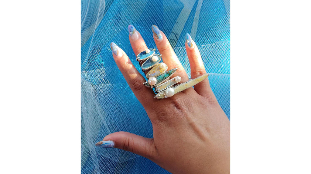 A stack of “Aqualescence” rings, including the “Island Bar,” fourth from top. (Photo credit: Ashley G. Garner/Image courtesy of Angely Martinez) A stack of “Aqualescence” rings, including the “Island Bar,” fourth from top. (Photo credit: Ashley G. Garner/Image courtesy of Angely Martinez)